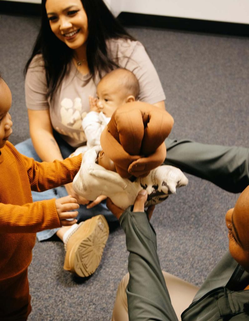ujima scholarship. Image of Ujima doulas showing toddler baby doll for childbirth class.